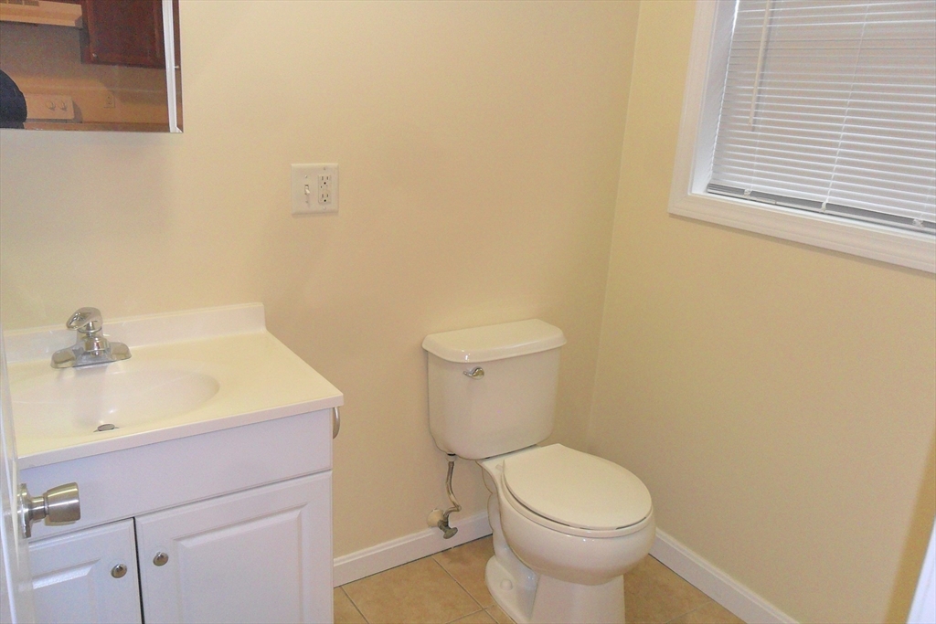 848 Waverly Street, Unit 4 Framingham, MA 01702 - Photo 4 of 14 a bathroom with a sink a toilet and a mirror