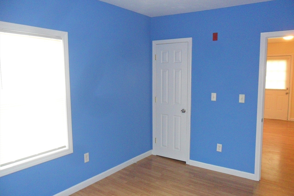 848 Waverly Street, Unit 4 Framingham, MA 01702 - Photo 9 of 14 a view of an empty room with wooden floor and a window