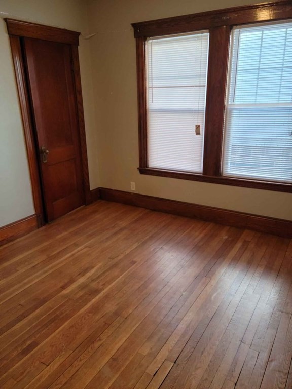 57 Austin Street, Unit 2 Boston, MA 02136 - Photo 11 of 17 an empty room with wooden floor and windows