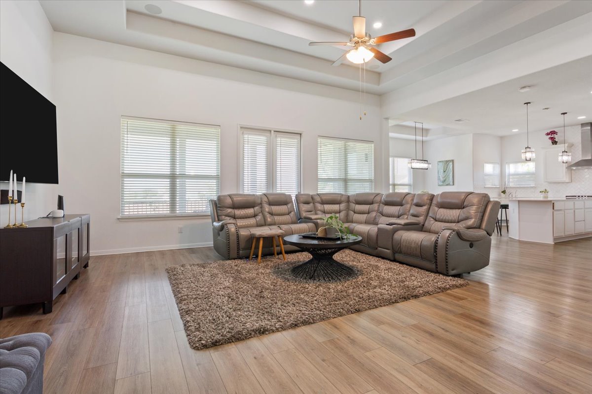 3625 Garrano Bend Leander, TX 78641 - Photo 6 of 38 Natural light fills this open concept living space with warm wood floors and high tray ceilings.