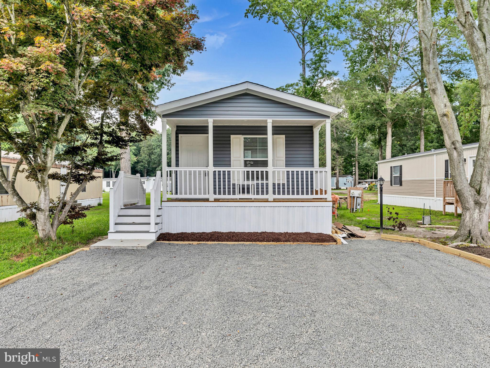 12623 Shell Mill Road, Unit 56 Bishopville, MD 21813 - Photo 1 of 73 a view of a house with a small yard and large trees