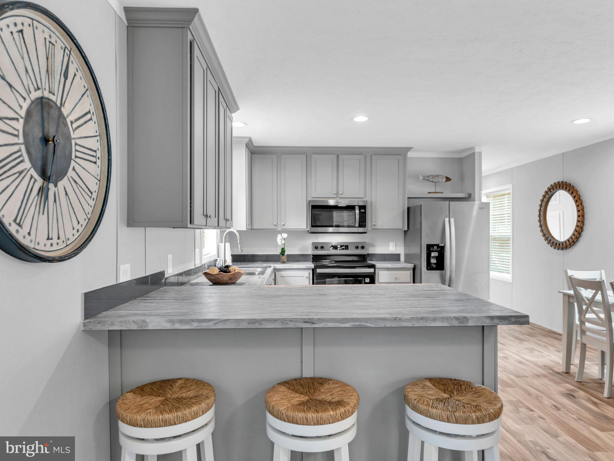 12623 Shell Mill Road, Unit 56 Bishopville, MD 21813 - Photo 12 of 73 a kitchen with stainless steel appliances a dining table and chair