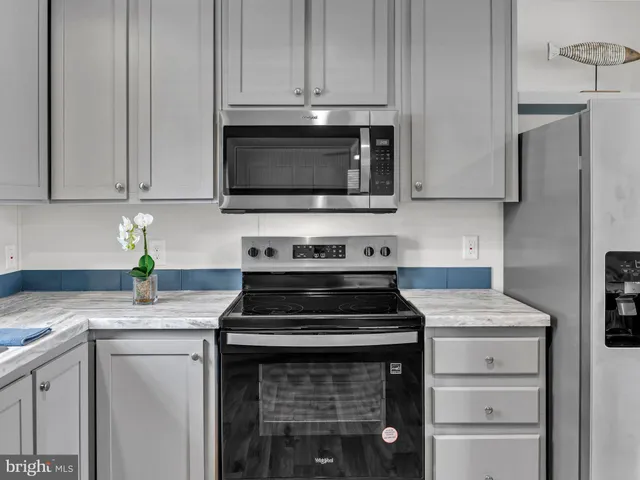 a kitchen with stainless steel appliances granite countertop a stove a sink a refrigerator and a microwave