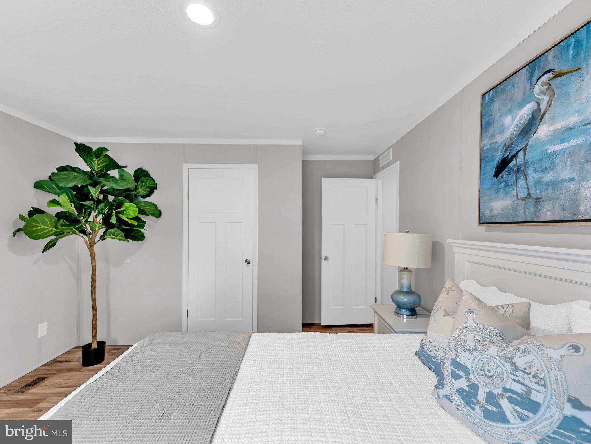 12623 Shell Mill Road, Unit 56 Bishopville, MD 21813 - Photo 39 of 73 a bedroom with a bed and a potted plant