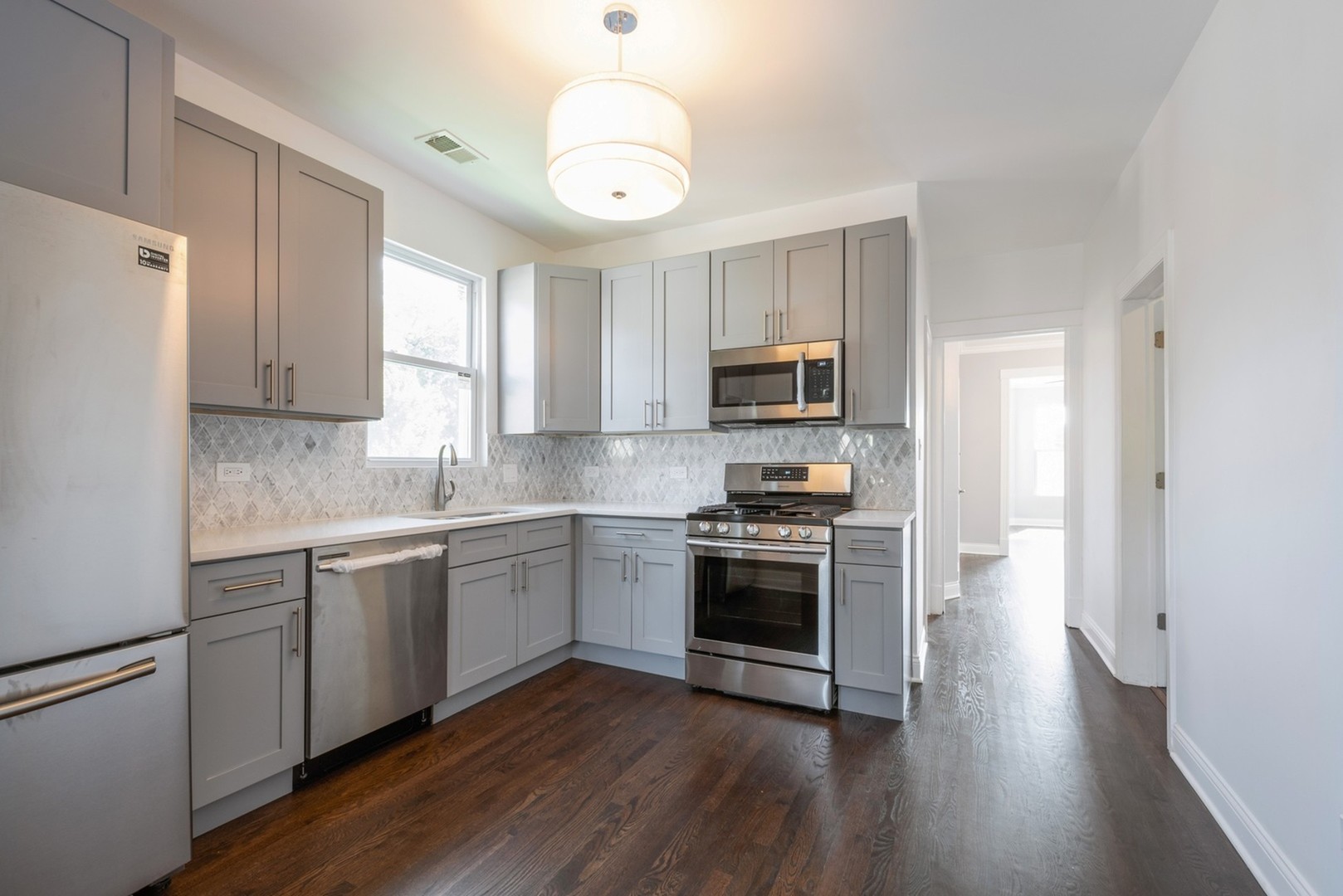 4226 North Bernard Street, Unit 2 Chicago, IL 60618 - Photo 3 of 9 a kitchen with granite countertop white cabinets and stainless steel appliances