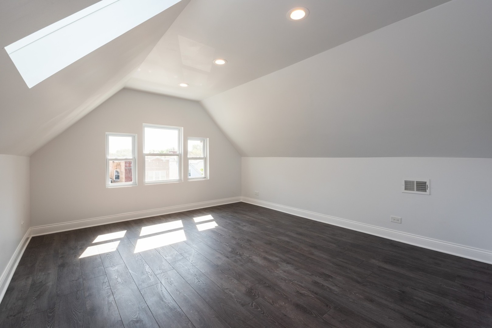 4226 North Bernard Street, Unit 2 Chicago, IL 60618 - Photo 7 of 9 an empty room with wooden floor and windows