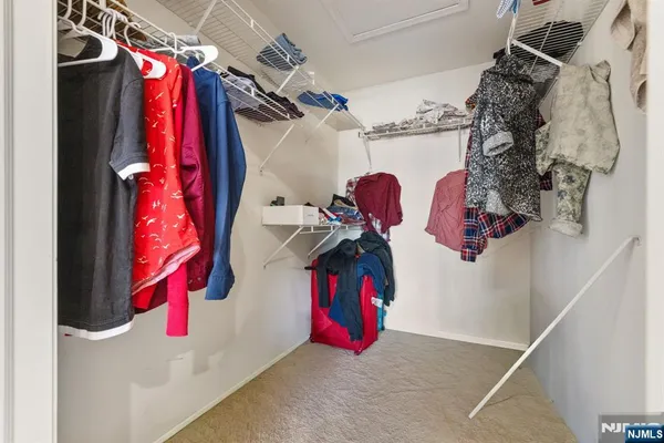 a view of walk in closet with clothes and shoes