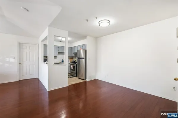 a view of a kitchen with a refrigerator and wooden floor