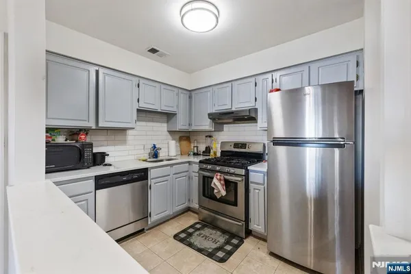 a kitchen with stainless steel appliances granite countertop a refrigerator stove a sink and a granite counter tops