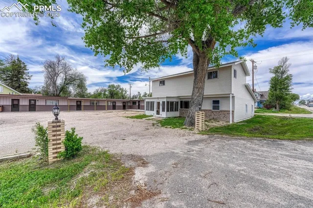 a view of a house with backyard and a tree