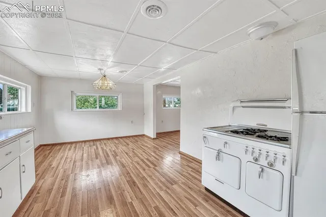 a view of a kitchen with cabinets and wooden floor