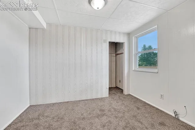 an empty room with a cabinet and mirrors