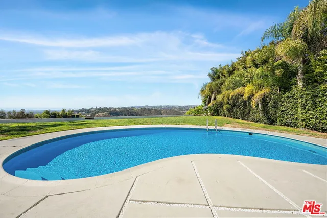 a view of a balcony with floor to ceiling windows and wooden fence