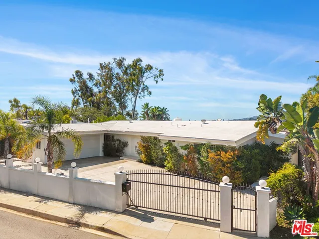 a view of a house with a yard and potted plants