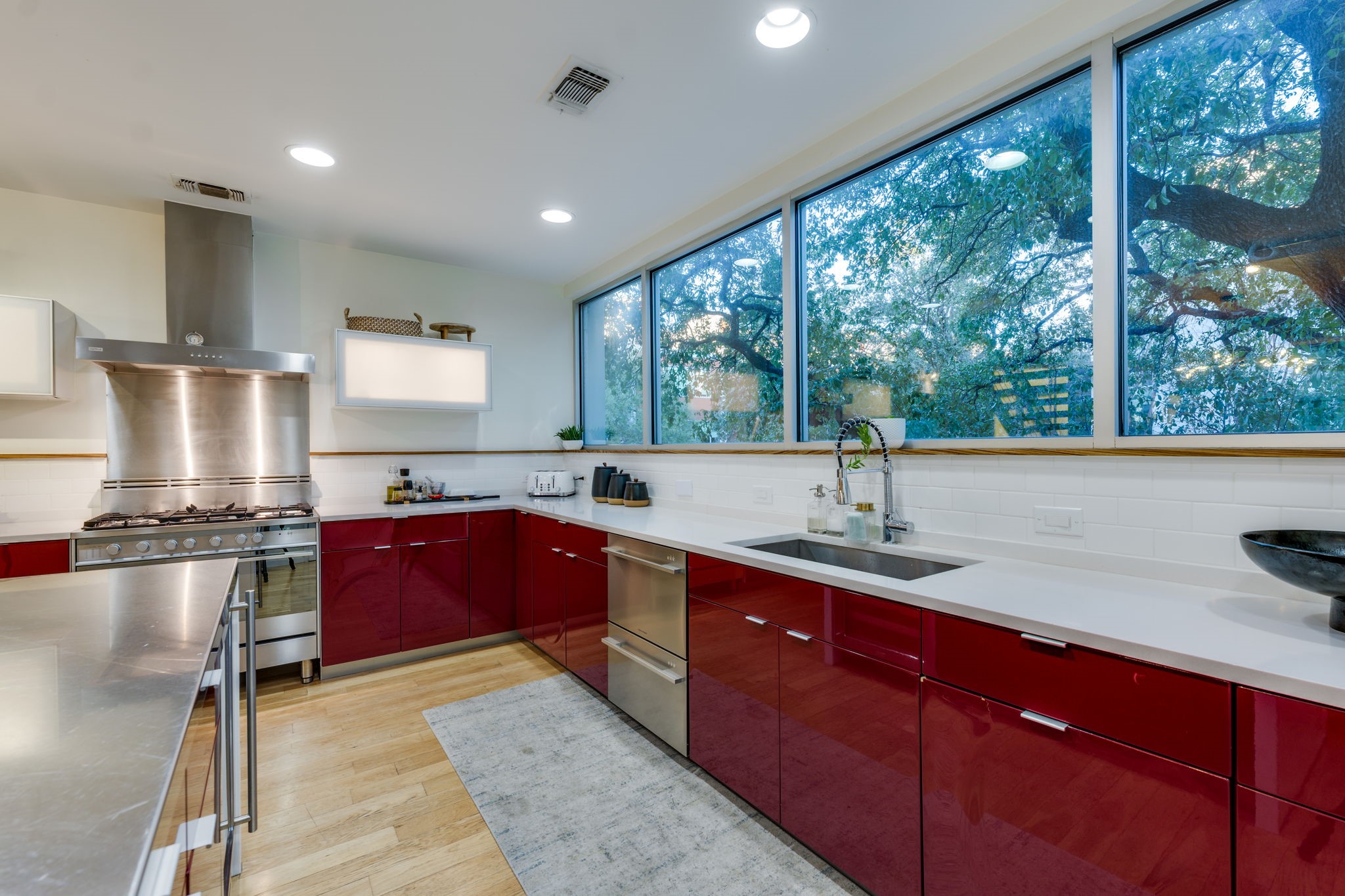 2301 South 5th Street, Unit 5 Austin, TX 78704 - Photo 20 of 39 Kitchen with sink, stainless steel gas range oven, light hardwood / wood-style floors, decorative backsplash, and wall chimney range hood