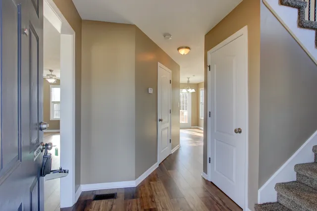 a view of a hallway with wooden floor and staircase