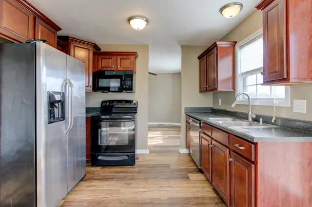 a kitchen with stainless steel appliances granite countertop a refrigerator and a sink