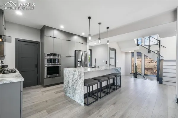 a living room with stainless steel appliances kitchen island granite countertop furniture wooden floor and a kitchen view
