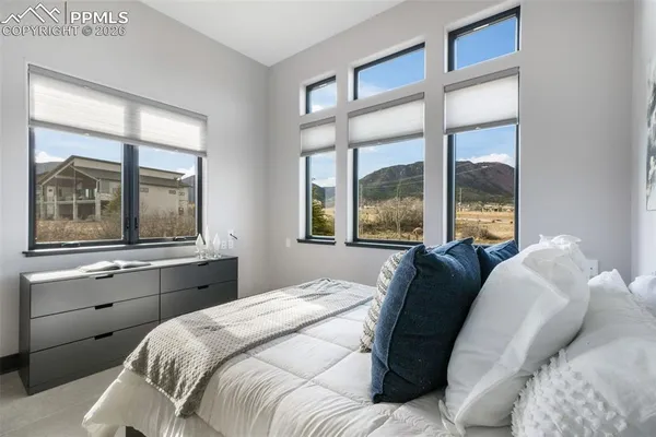 a bedroom with a bed and a large window
