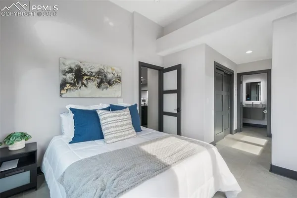 a bedroom with a bed and a painting on the wall