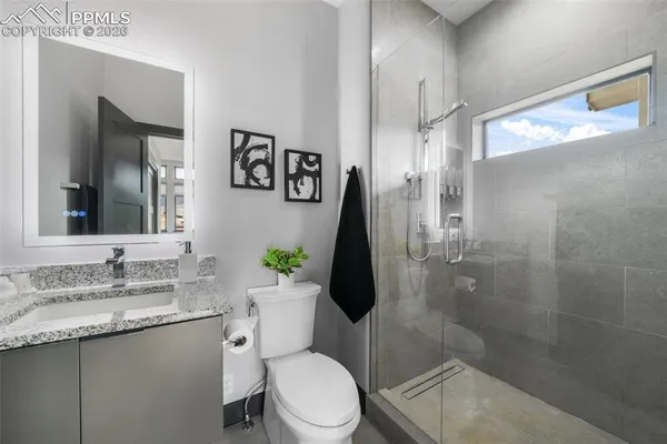 a bathroom with a granite countertop toilet sink and shower