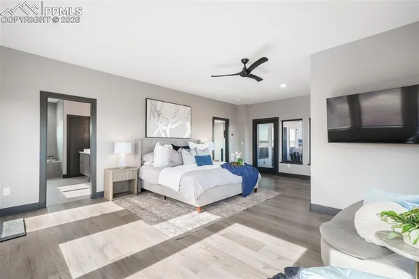 a spacious bedroom with a large bed and flat screen tv