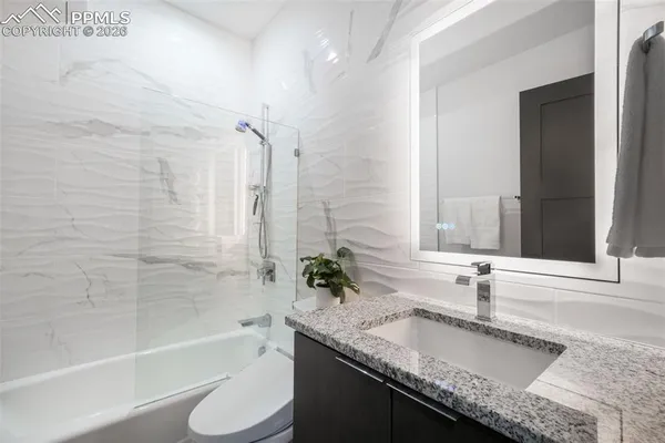 a bedroom with a bed and painting on the wall