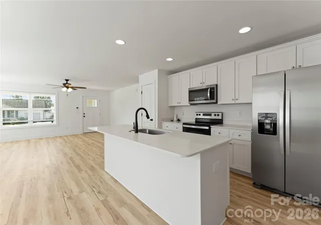 a kitchen with sink and mirror