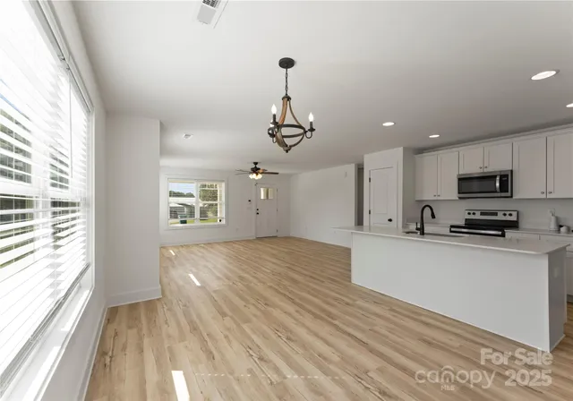 a kitchen with stainless steel appliances granite countertop a sink a stove top oven a counter space and cabinets