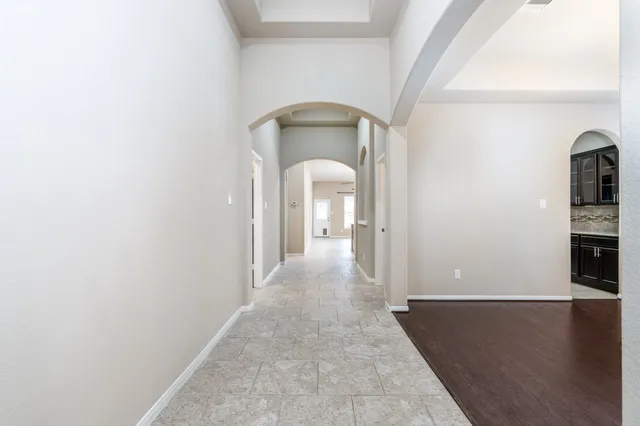 a view of a hallway with wooden floor and a living room