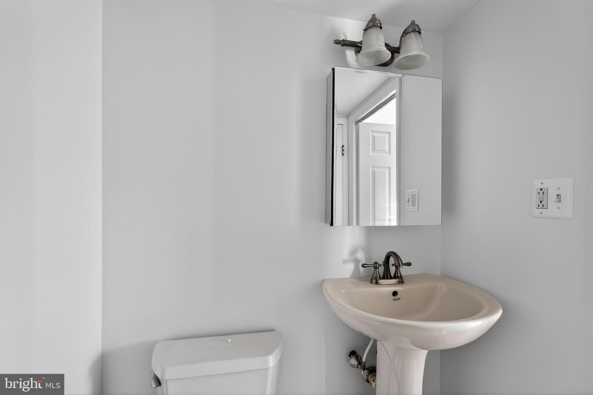 800 South Avenue, Unit B4 Secane, PA 19018 - Photo 7 of 16 a bathroom with a sink a mirror and a toilet