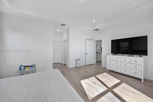 a living room with flat screen tv and a dresser