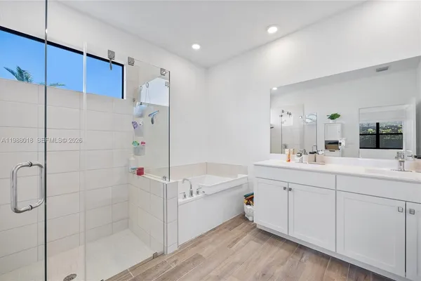 a bathroom with a tub sink and mirror