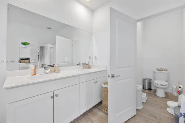 a bathroom with a double vanity sink mirror and toilet