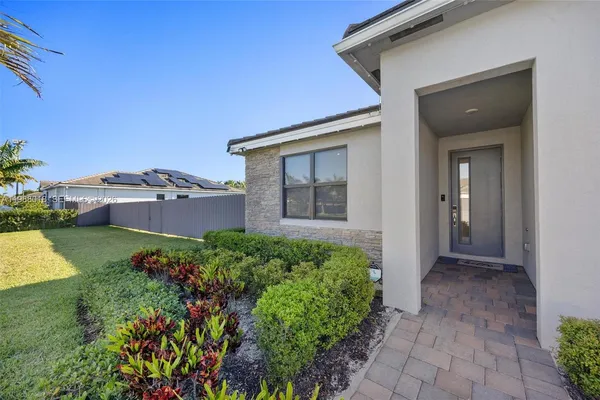 a view of a house with a yard and potted plants
