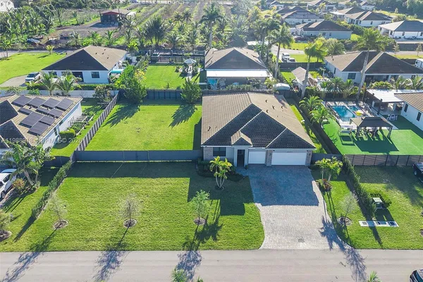 an aerial view of a house with a swimming pool garden and patio