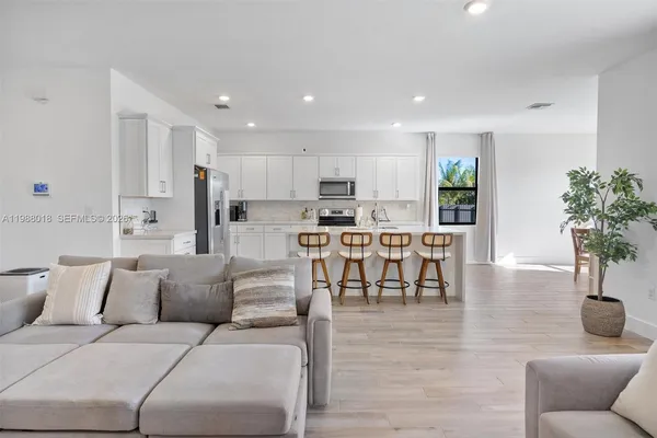 a living room kitchen with furniture and a dining table with kitchen view