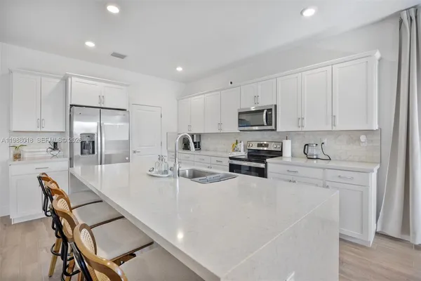 a kitchen with refrigerator and white cabinets