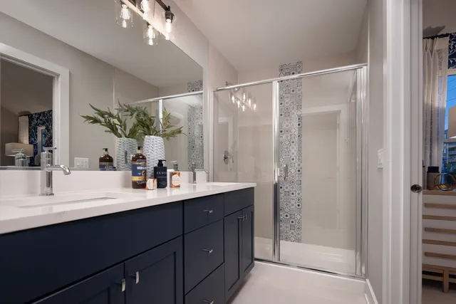 a bathroom with a double vanity sink mirror and shower