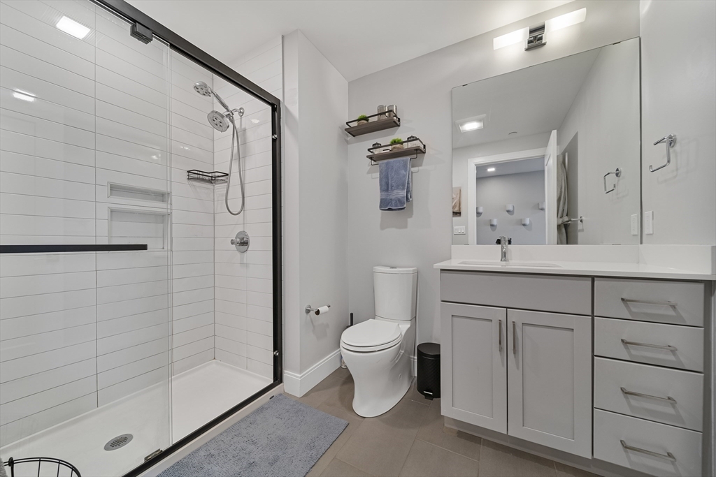 11 Walley Street, Unit 202 Boston, MA 02128 - Photo 14 of 24 a bathroom with a double vanity sink toilet and shower