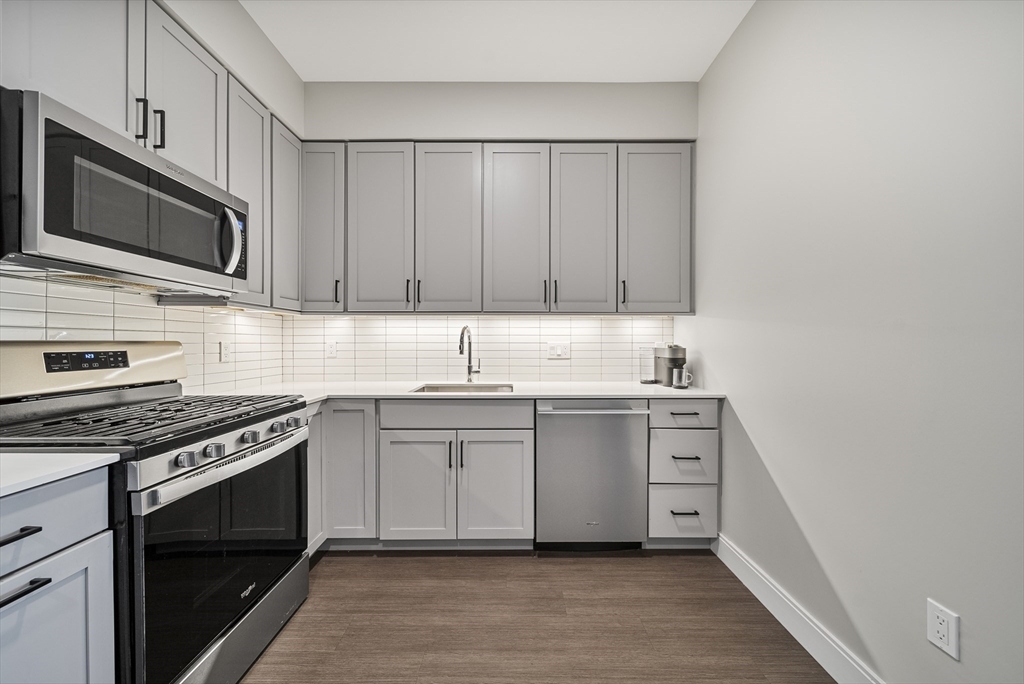 11 Walley Street, Unit 202 Boston, MA 02128 - Photo 4 of 24 a kitchen with stainless steel appliances white cabinets and a stove top oven