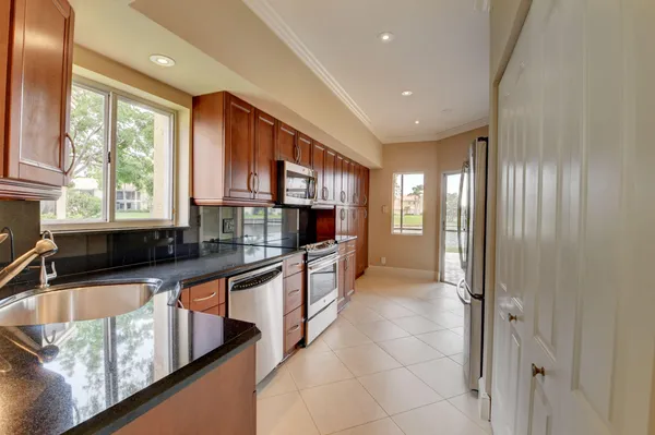 a kitchen with stainless steel appliances granite countertop a refrigerator and a sink