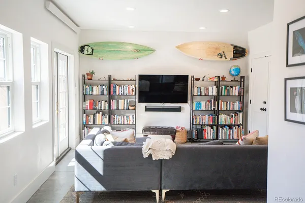 a living room with furniture a flat screen tv and a book shelf