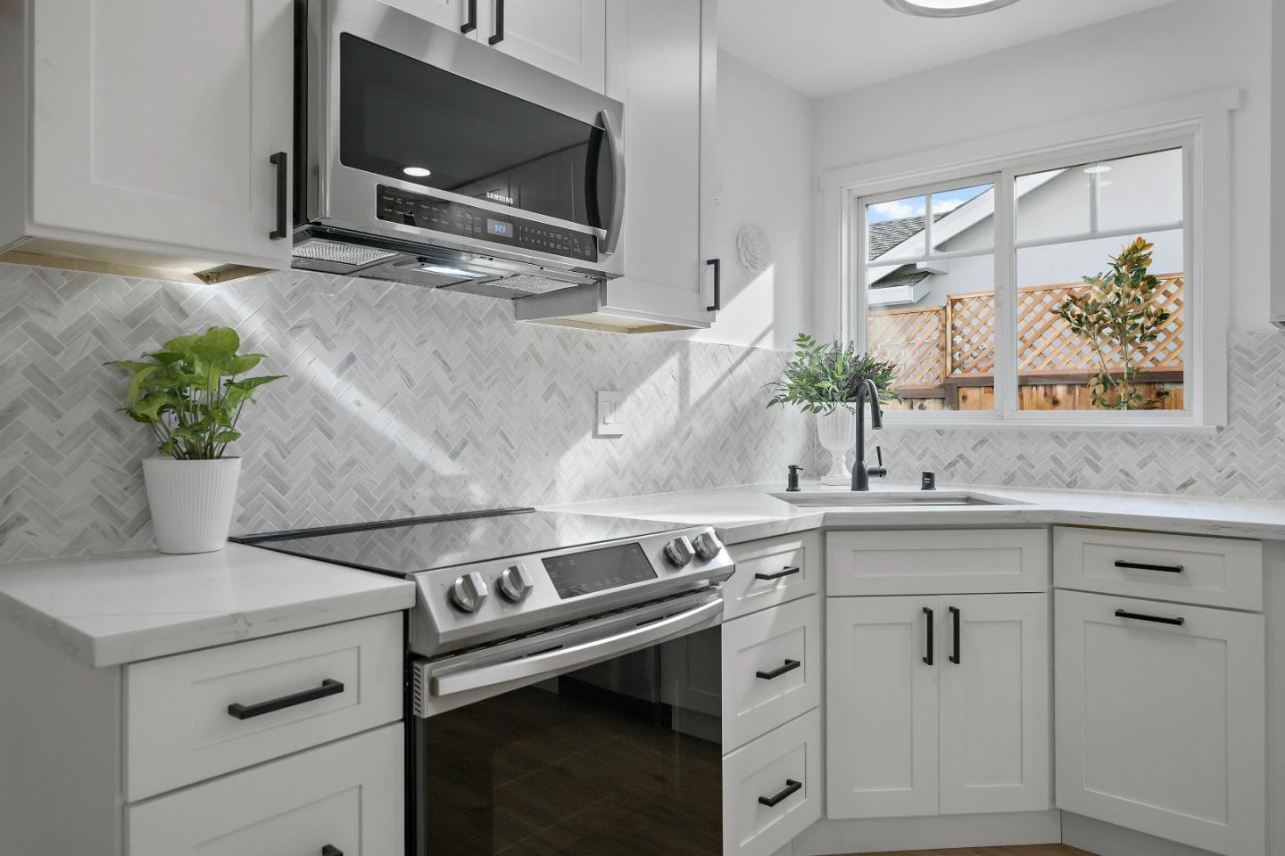 10275 Farallone Drive Cupertino, CA 95014 - Photo 7 of 17 a kitchen with stainless steel appliances white cabinets and a potted plant