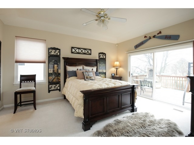 1150 Ridgewood Circle Lake In The Hills, IL 60156 - Photo 12 of 20 a spacious bedroom with a bed a table and painting on the wall