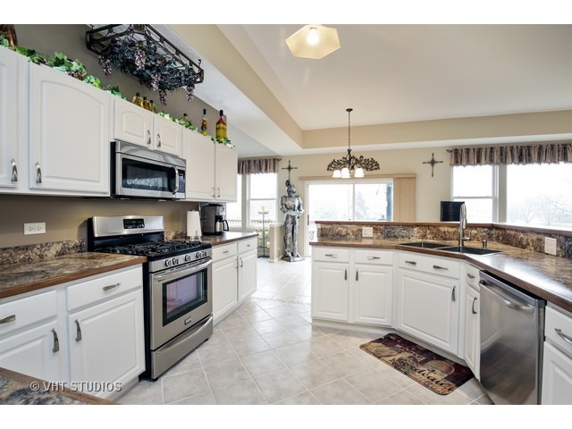 1150 Ridgewood Circle Lake In The Hills, IL 60156 - Photo 4 of 20 a kitchen with stainless steel appliances granite countertop a stove a sink and a microwave