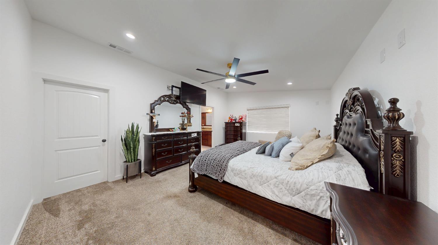 4460 South Carpenter Road Modesto, CA 95358 - Photo 22 of 40 a bedroom with a bed and a chandelier