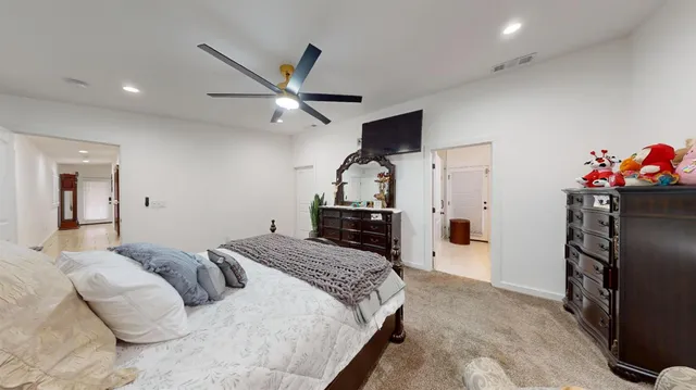 a spacious bedroom with a bed and a flat screen tv