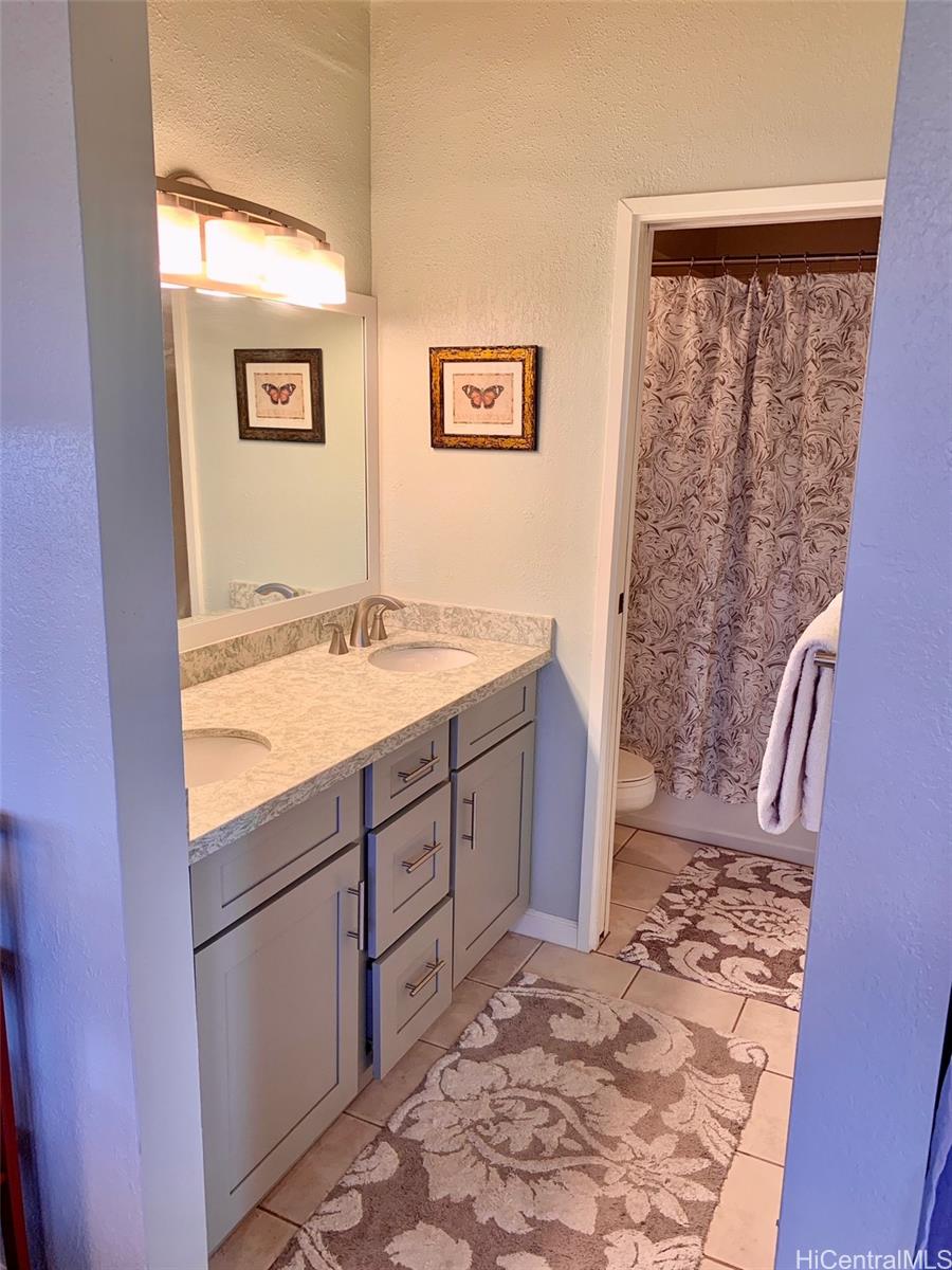 45-315 Lilipuna Road, Unit A306 Kaneohe, HI 96744 - Photo 11 of 19 a bathroom with a granite countertop sink and a mirror