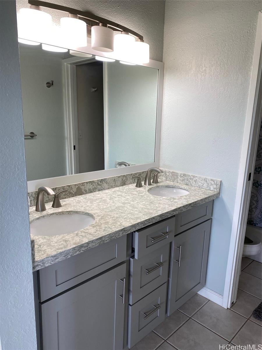 45-315 Lilipuna Road, Unit A306 Kaneohe, HI 96744 - Photo 12 of 19 a bathroom with a granite countertop sink and a mirror